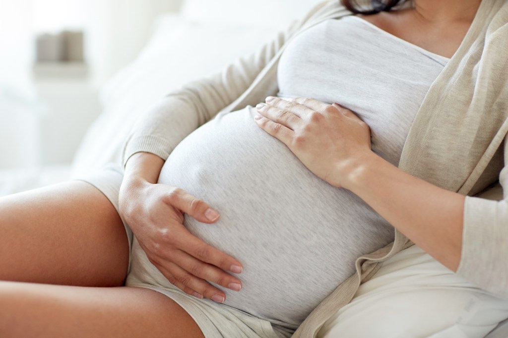 A pregnant woman holding her belly